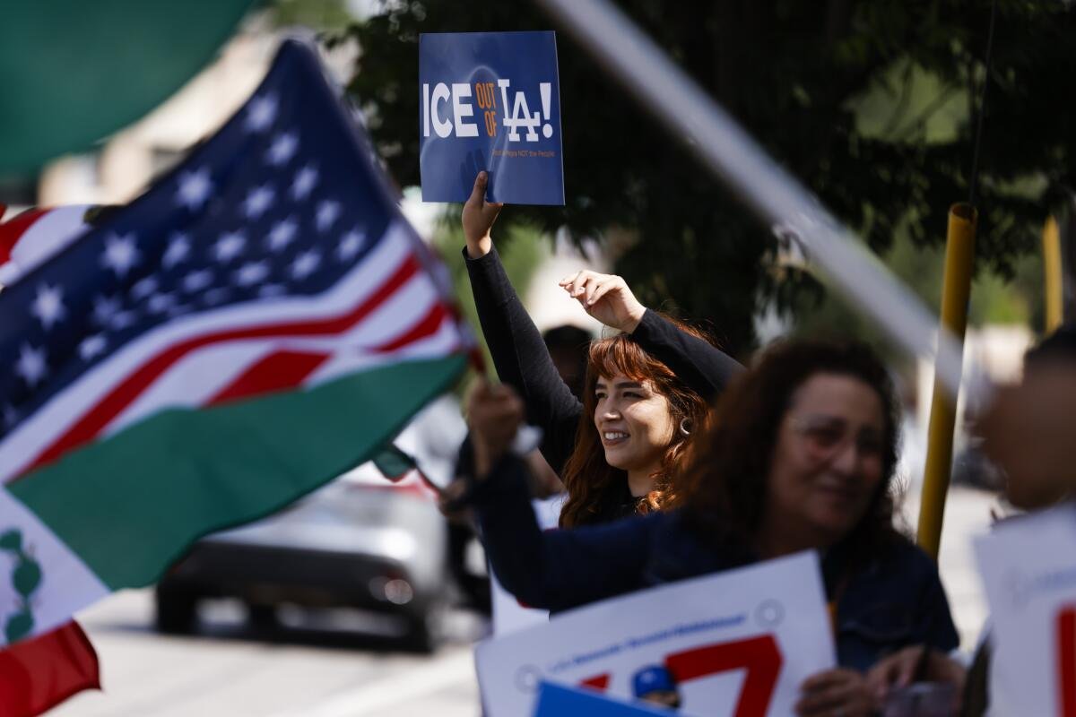 People holding signs and waving U.S. and Mexico flags