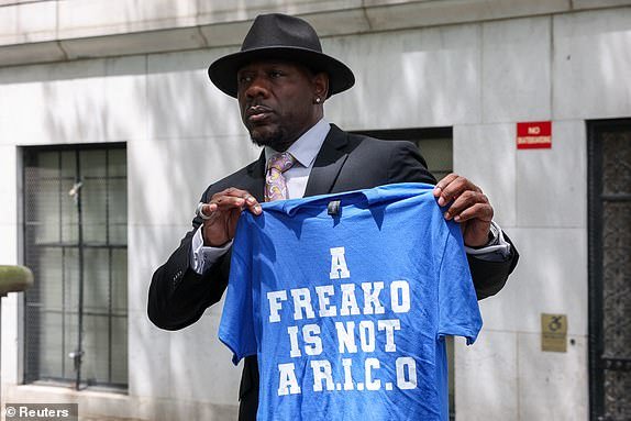 A man holds a t-shirt reading "A freako is not a R.I.C.O" outside a U.S. federal court, where deliberations are underway for Sean "Diddy" Combs' sex trafficking and racketeering conspiracy trial in Manhattan in New York City, U.S., July 1, 2025. REUTERS/Kylie Cooper