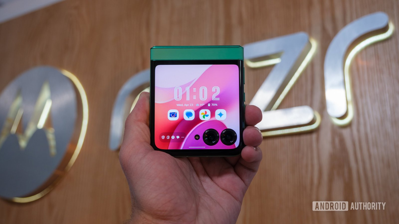 Motorola Razr 2025 held in front of logo Motorola Razr 2025 held in front of logo