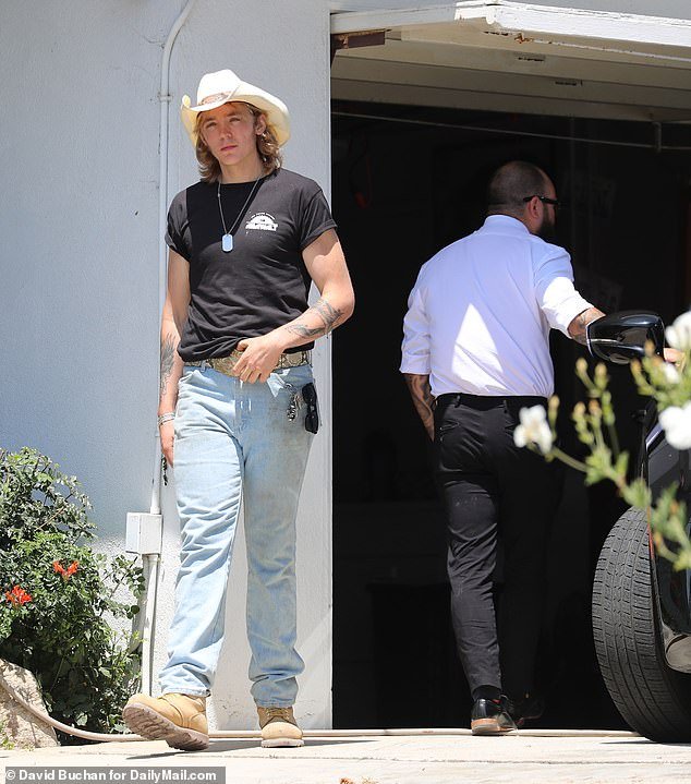 The teenager was also spotted walking down the driveway as a car, seemingly belonging to the coroner, slowly backed into it