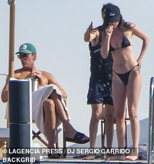 A black cap was placed on top of her brunette locks that flowed down past her shoulders in natural waves