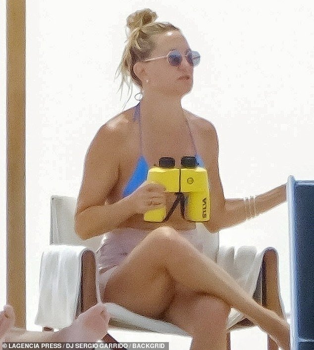 The mom-of-three accessorized her swimsuit with mini earrings as well as flashy bracelets on her left wrist